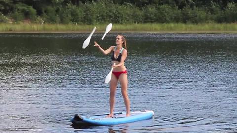 Acrobatic juggling act while on a stand up paddle board!