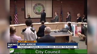 Four Ann Arbor city councilmembers take a knee during Pledge of Allegiance