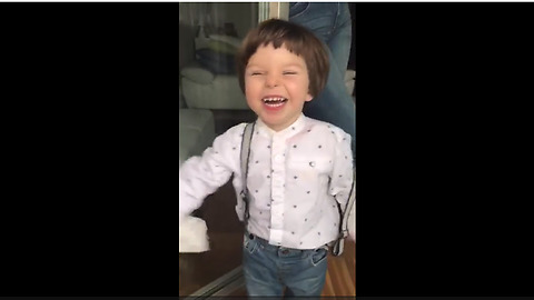 Toddler blows raspberries to help clean the windows