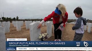 Group puts flags, flowers on graves