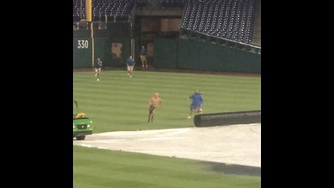 Man runs onto baseball field during ran delay, slides on water-filled tarp