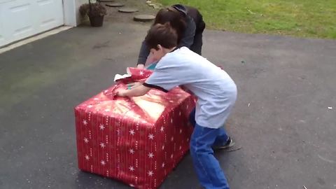 "Three Kids Scream With Excitement When They Open A Christmas Gift"