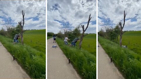 Men Fall Down While Attempting To Break Tree On Roadside