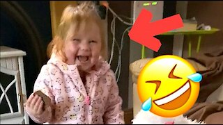 Child laughs hysterically at her toy puppy falling off the table