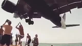 The plane flies over the beach