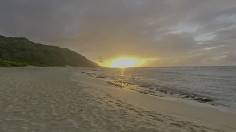 Mokuleia Army Beach at sunset with full sky rainbow on island of Oahu in Hawaii