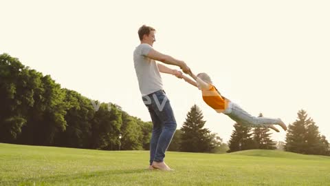 Happy Father Holding Her Little Daughter And Spinning Around On Meadow In The Park 1