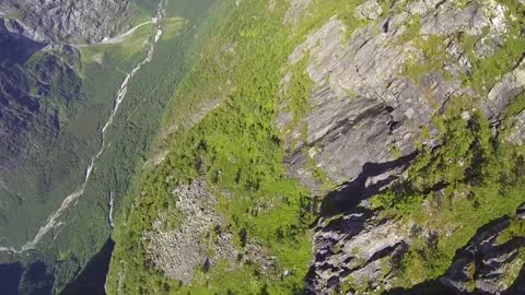 BASE jumper plunges down mountainside rockdrop
