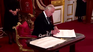 King Charles prompts aide to take pen away