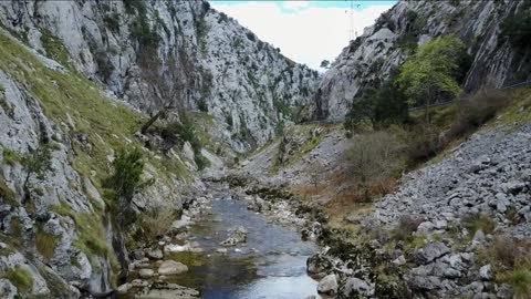 flying through a gorge above a river at picos de europa in spain