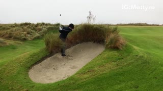 Man in sand hits golf ball falls flips