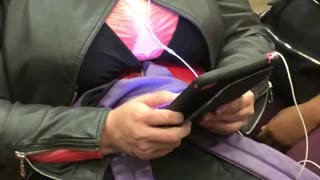Woman in costume and blonde wig on phone on train