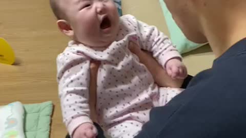 Baby crying looking at dad.