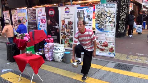 Street performer lands vases on his head using foot