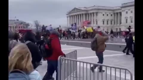 US Capitol Police Officer waving protesters past barricade