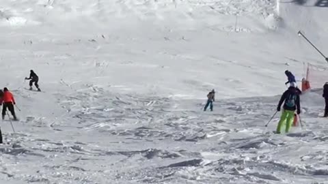 Girl in all black skis down snow slope