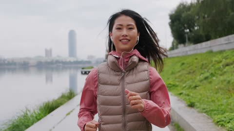 A woman wearing a smile while jogging