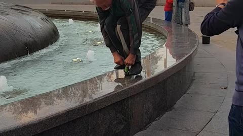 Man Rides a Tiny Bike on a Fountain