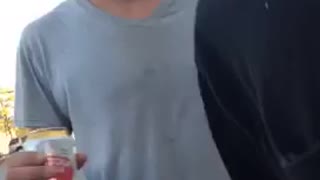 Guy black shirt knocking beer of guy grey shirt