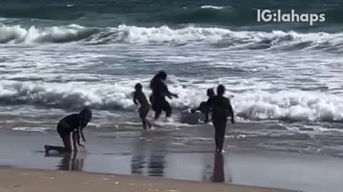 Man carries white mattress on beach