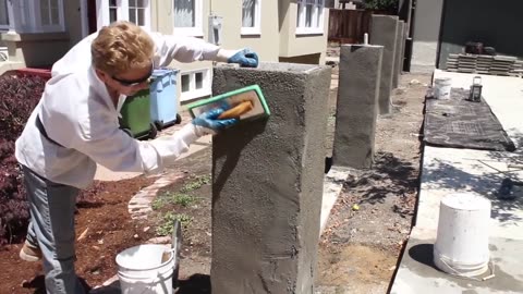 Apply stucco cement over concrete block pillars.