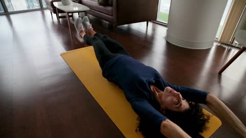 Slow Motion Footage OF A Woman Exercising On A Yoga Mat In The Living Room Floor