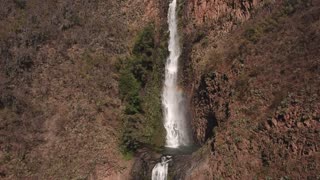 A small waterfall emerges between two mountains