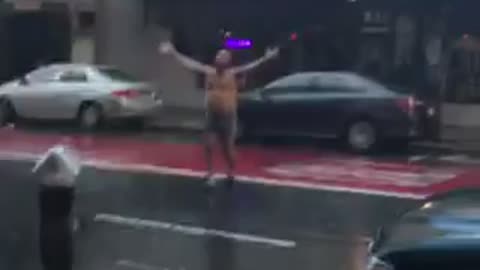 Man goes outside his shop In sanfransisco out in the heavy rain to take a shower