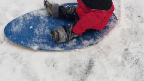 Baby flies down the hill on the snow
