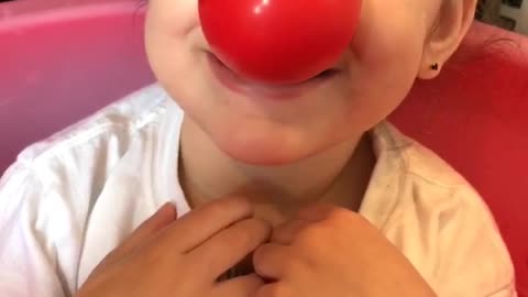baby girl pretends to be a clown