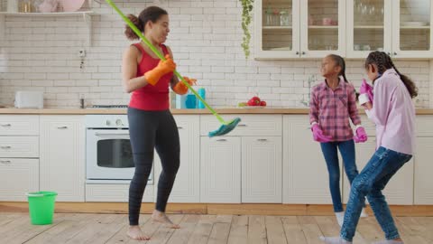 Mother and daughters in a kitchen dancing