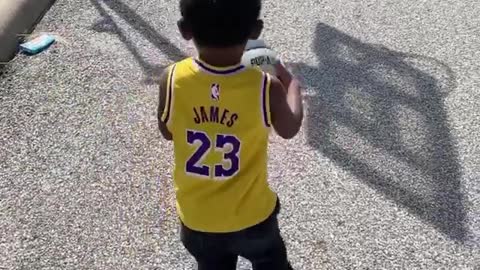 Watch this toddler drill a long distance basketball shot with ease