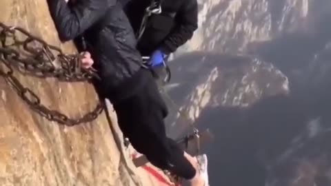 Man dangling from a cliff