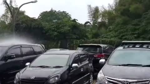Rain pours on only one car during storm in Indonesia