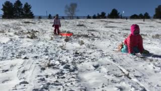 Mom on sled with little girl in pink gets dropped off in snow