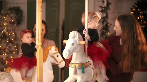 Mothers putting their babies on a carousel