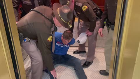 Man forcefully removed, handcuffed, detained and criminally charged for wearing a "We The People" shirt