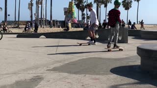 Kid in white shirt near beach skateboard