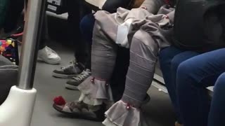 Man in clown it outfit sitting on the train