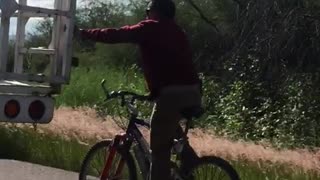 Bicycle Rider Holds onto Truck Tailgate