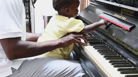 toddler playing a piano