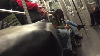 Guy red sweater yellow headphones singing on subway