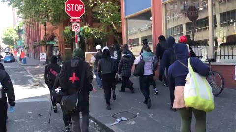 June 10 2017 Seattle 1.8 A group of Antifa walks past tourists visiting Seattle