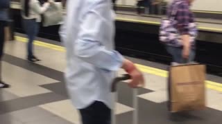 Man in all blue paint waits for subway