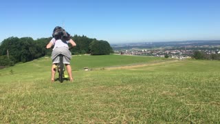 Traildog riding as backpack on mountainbike with owner