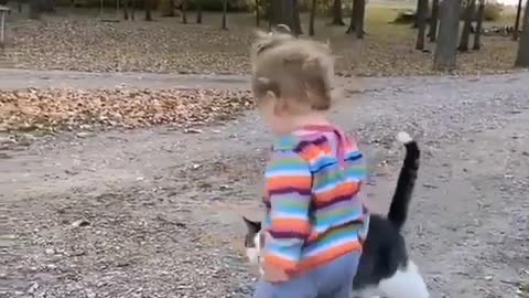 Lovely little girl playing with a sweet cat, kissing and talking to him