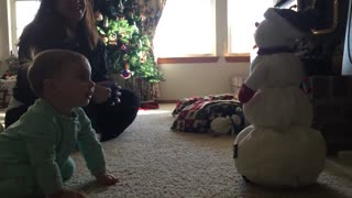 Adorable baby girl sad at melting snowman