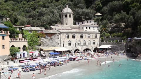 view of san fruttuoso di camogli italy italian riviera with sea rocky beach and people swimming