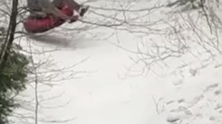 Guy sleds down snow hill, hits bump, and face plants into the ground