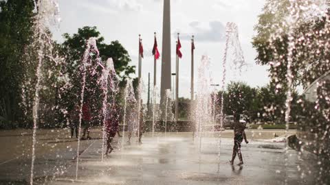 Slow Motion Footage Of Children And Adults Playing In The Water Fountains ...i.